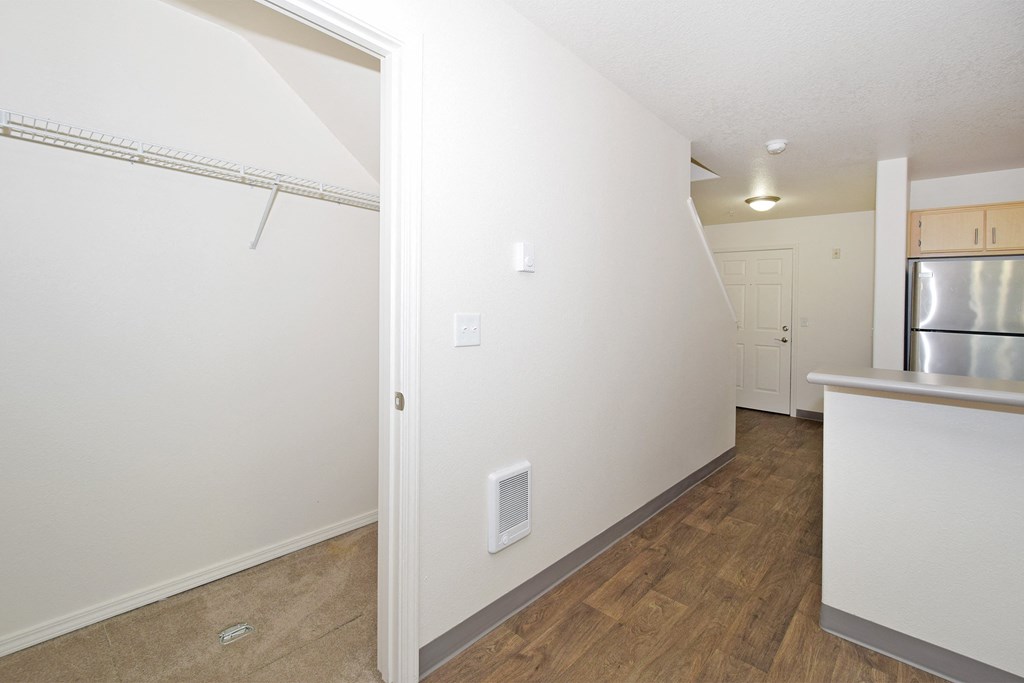 the living room and kitchen of an apartment with a stainless steel refrigerator
