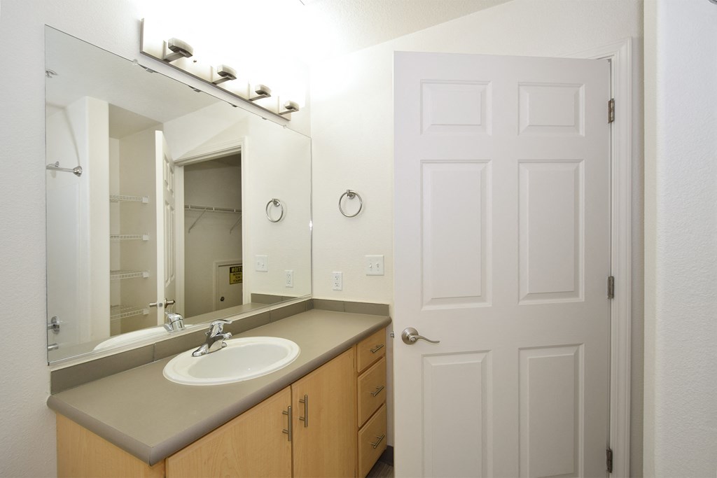 a bathroom with a sink and a mirror and a door