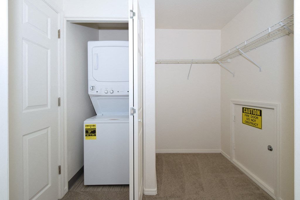 a laundry room with a washer and dryer and a closet with a door