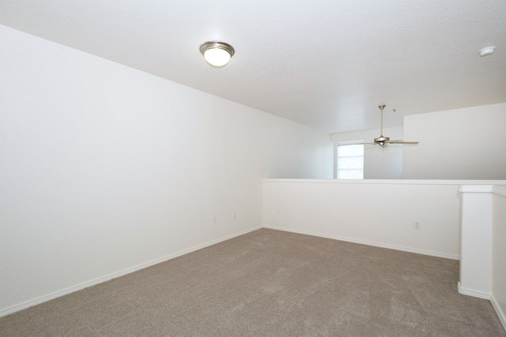 an empty living room with white walls and carpet