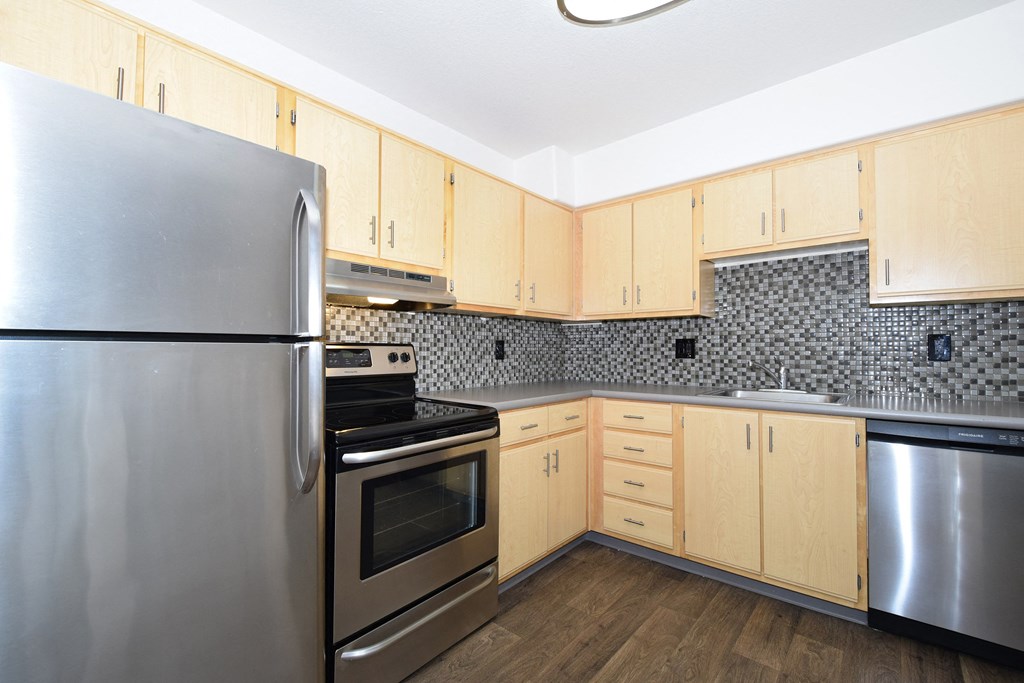 a kitchen with stainless steel appliances and wooden cabinets