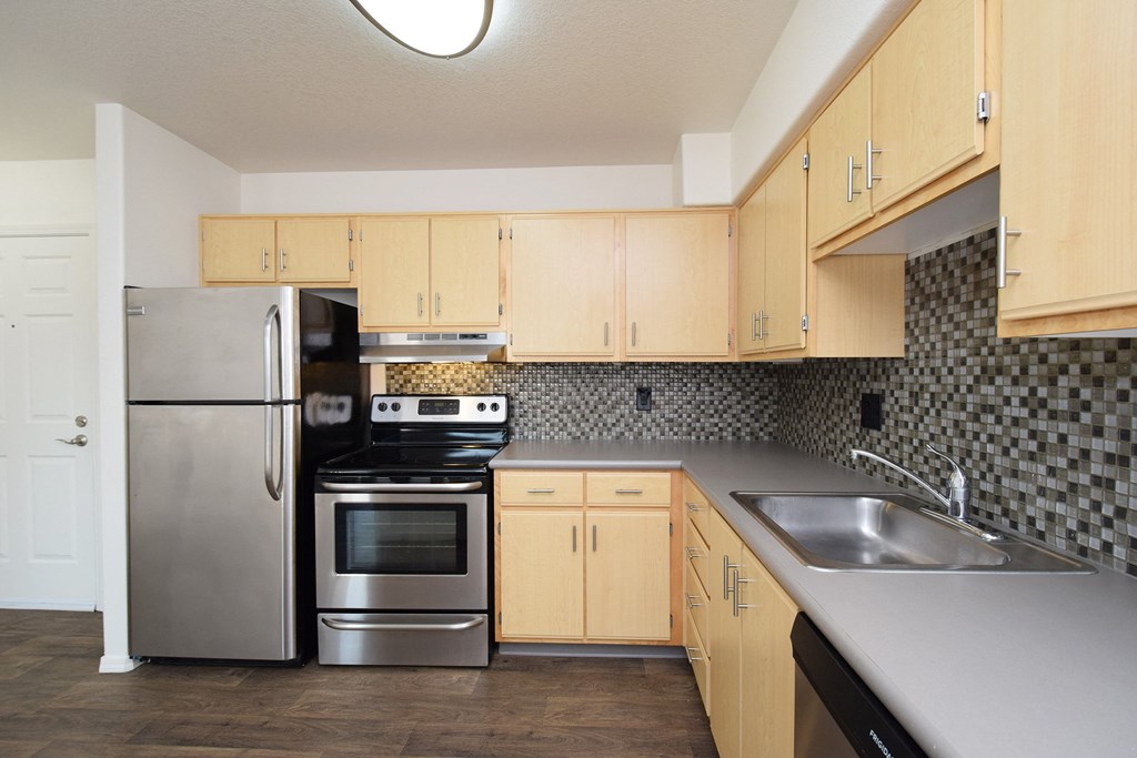 a kitchen with stainless steel appliances and wooden cabinets