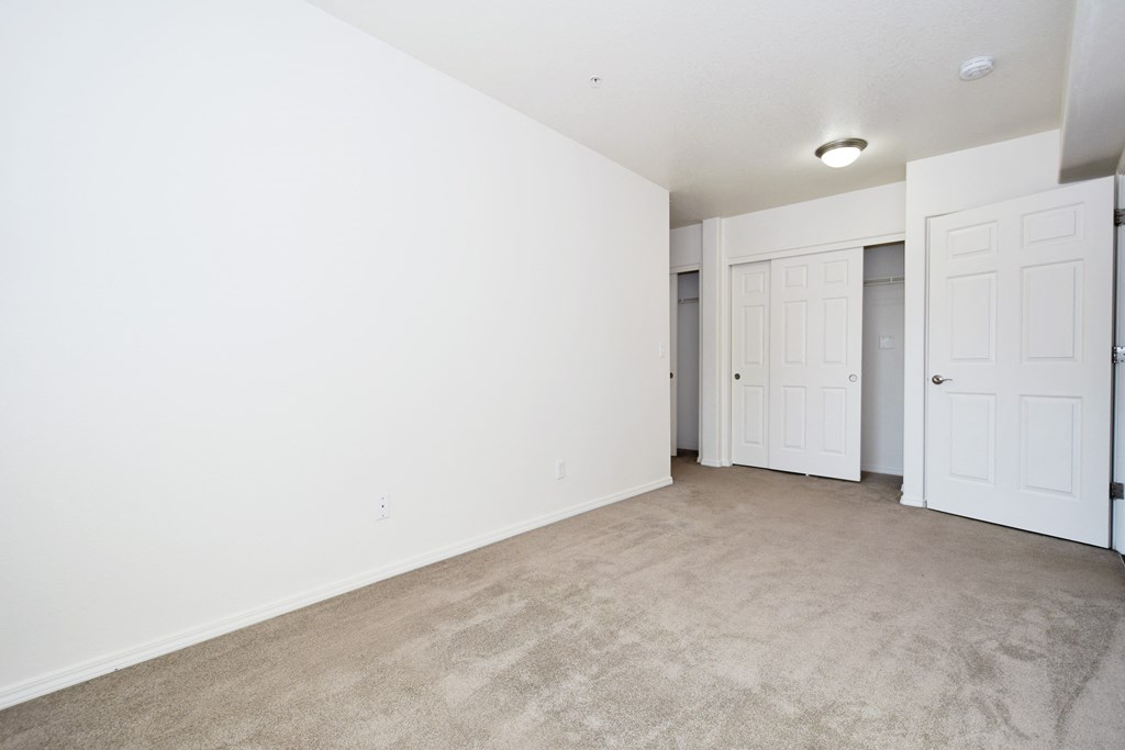 an empty living room with white walls and white doors
