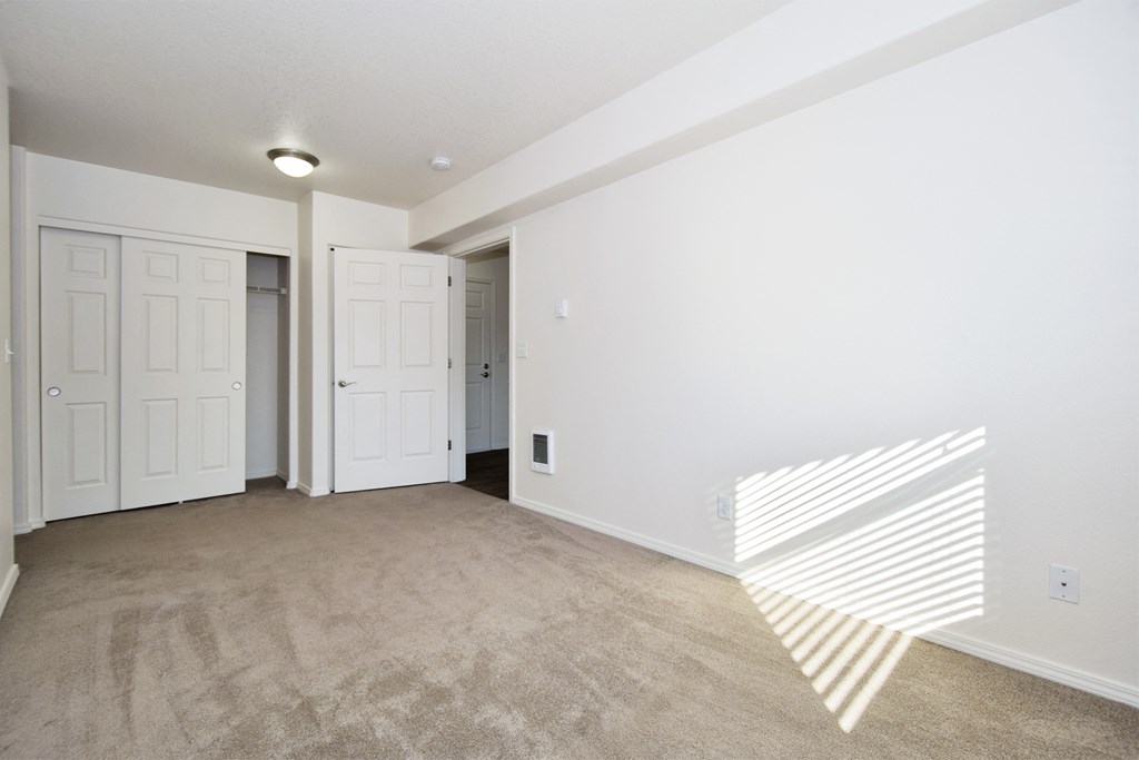 an empty living room with white walls and white doors and carpet
