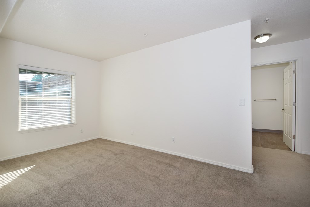an empty living room with a window and a door