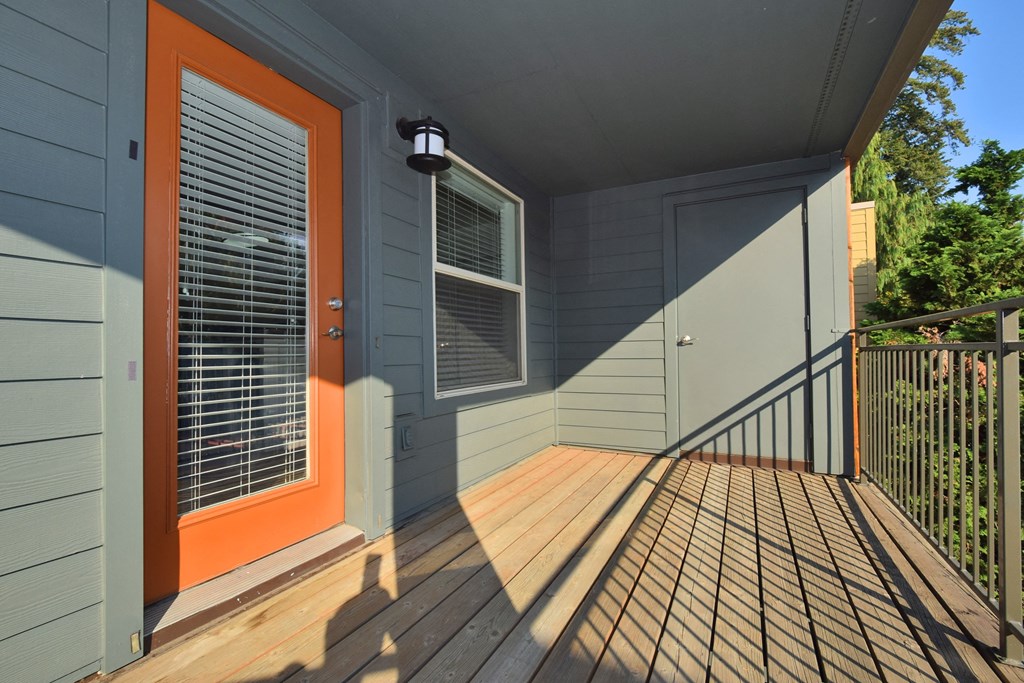 the front porch of a house with an orange door