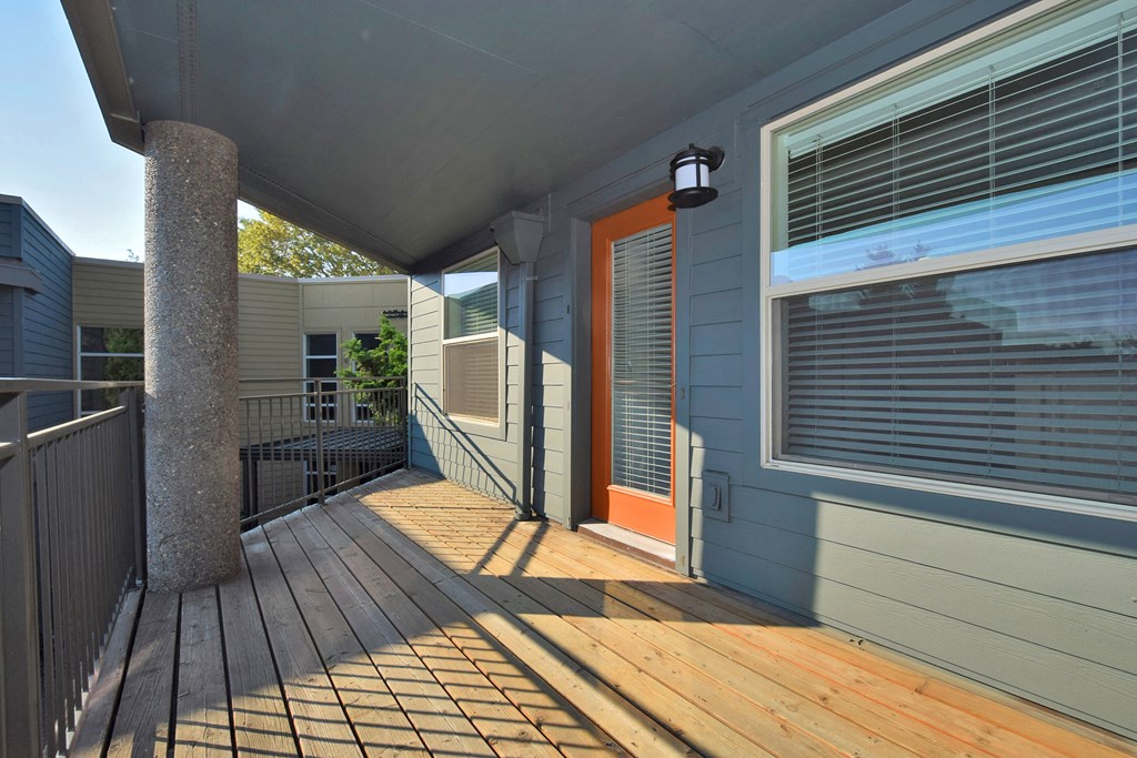 the front porch of a house with an orange door
