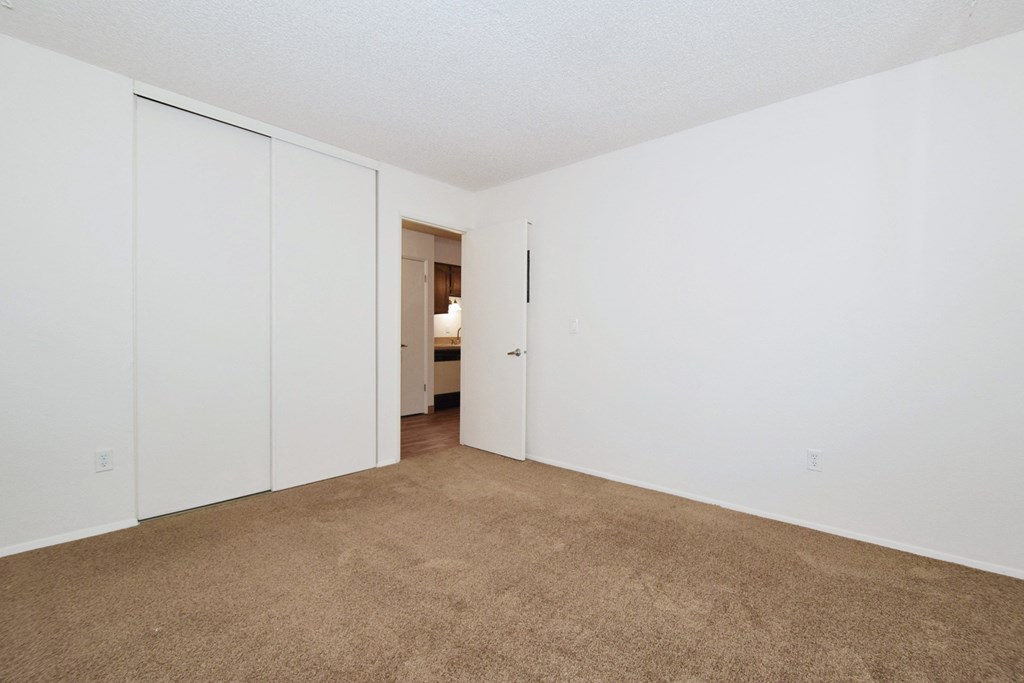 an empty living room with white walls and carpet