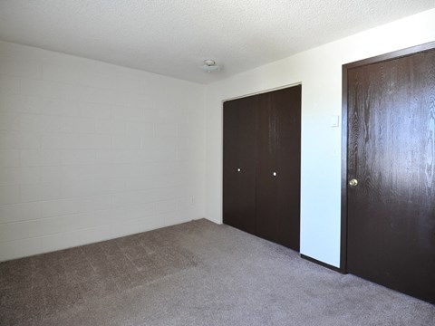 an empty living room with two doors and a carpet