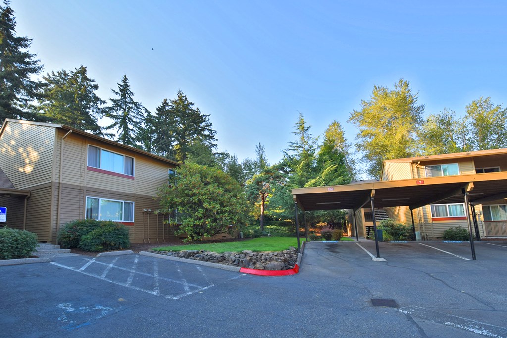 a parking lot in front of a building with trees