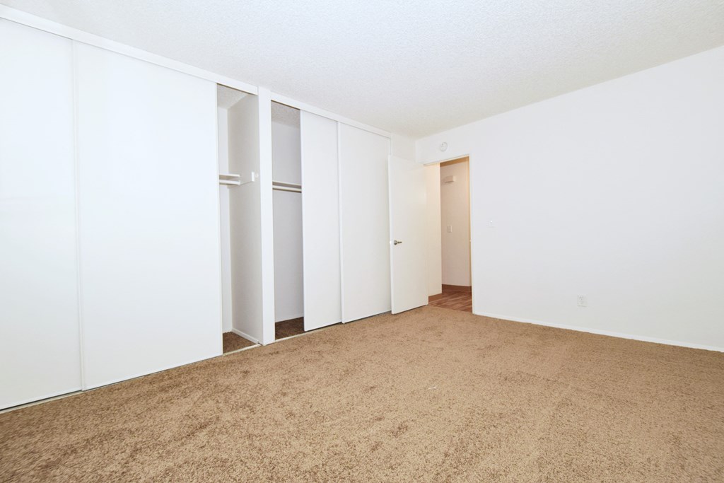 an empty living room with white walls and carpet