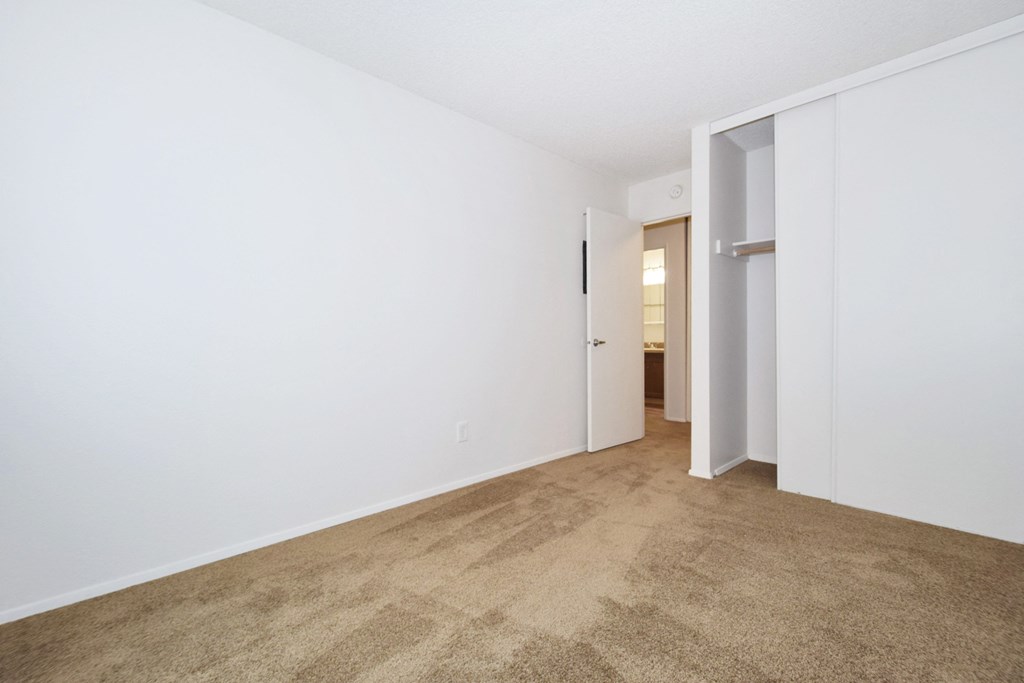 an empty living room with white walls and a carpet