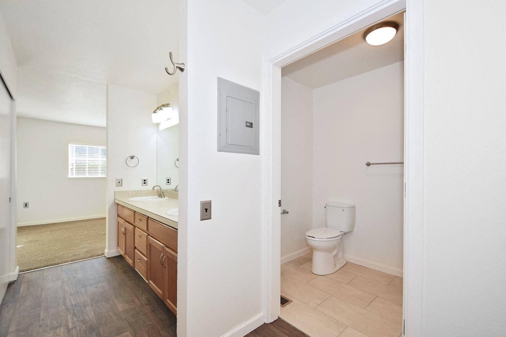 Twin Oaks Apartments a bathroom with a toilet and a sink and a mirror