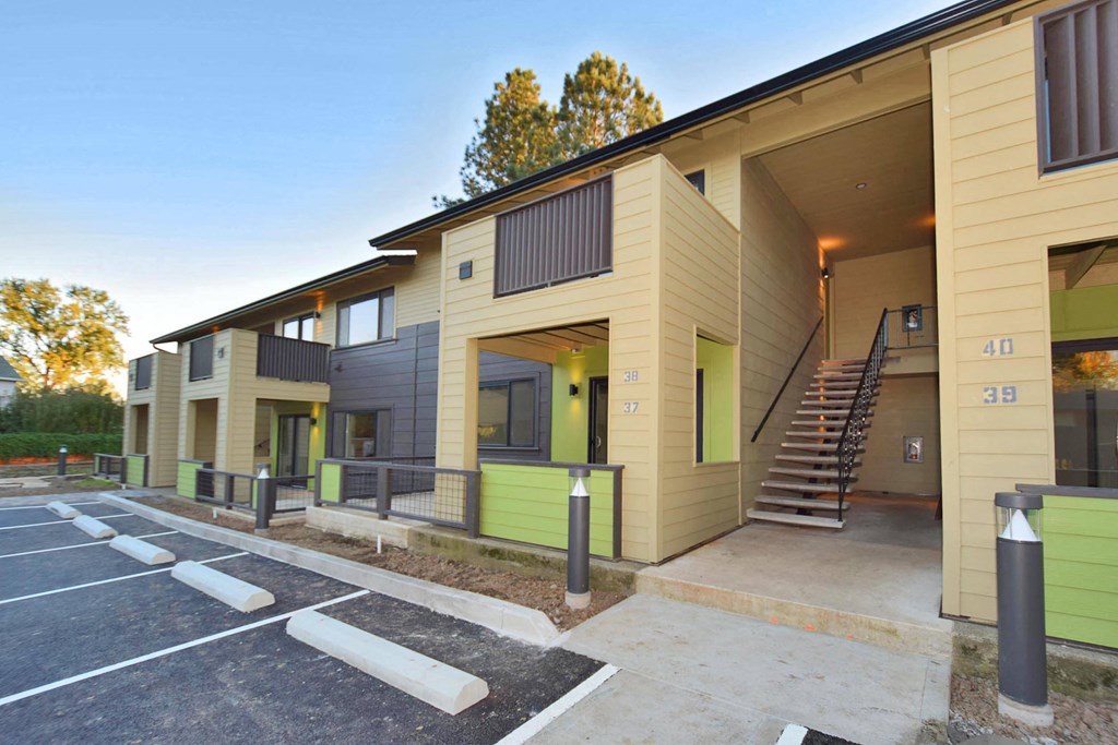 the exterior of a building with stairs and a parking lot