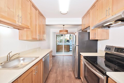 a kitchen with wooden cabinets and stainless steel appliances