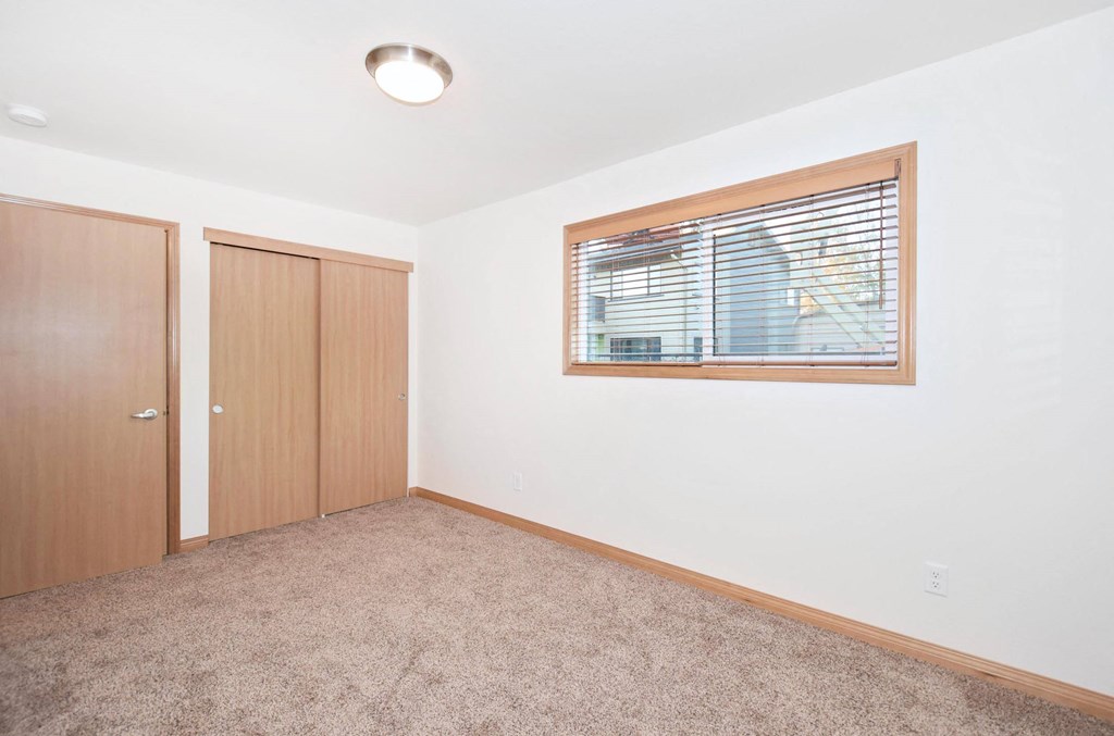 a room with a window and a door and a carpet