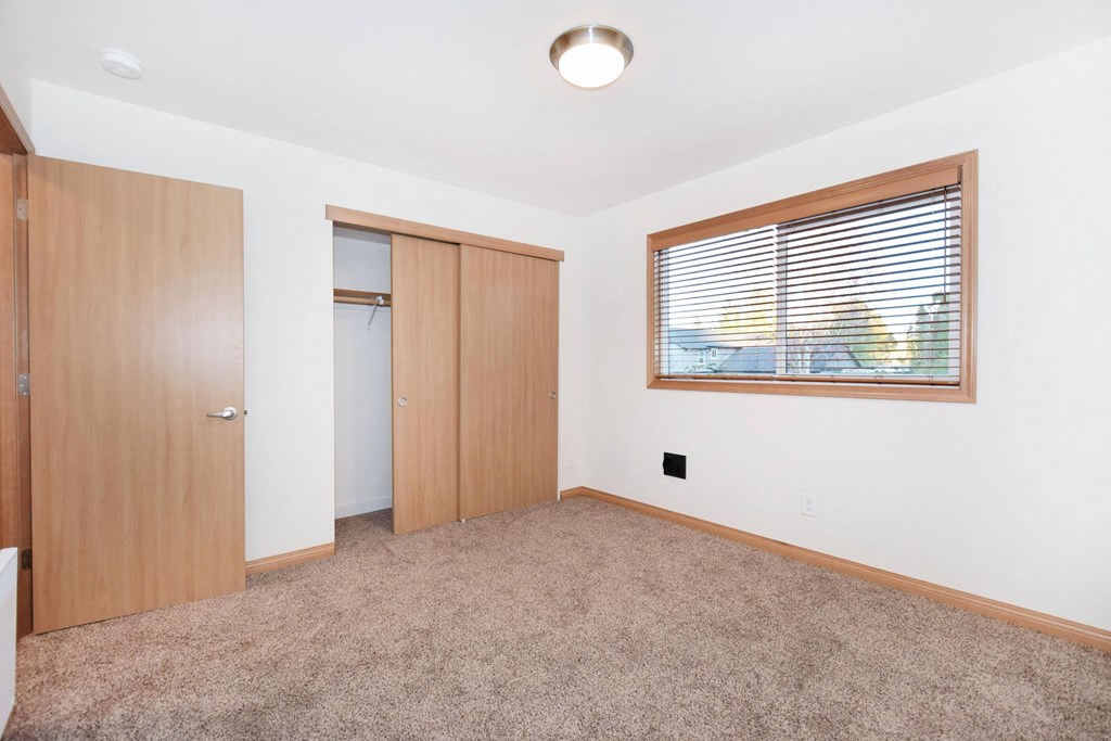 an empty living room with a window and a door
