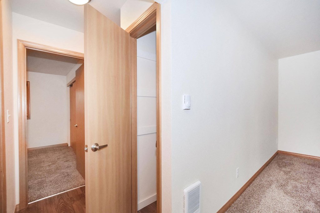 a bedroom with a door open to a hallway and a closet