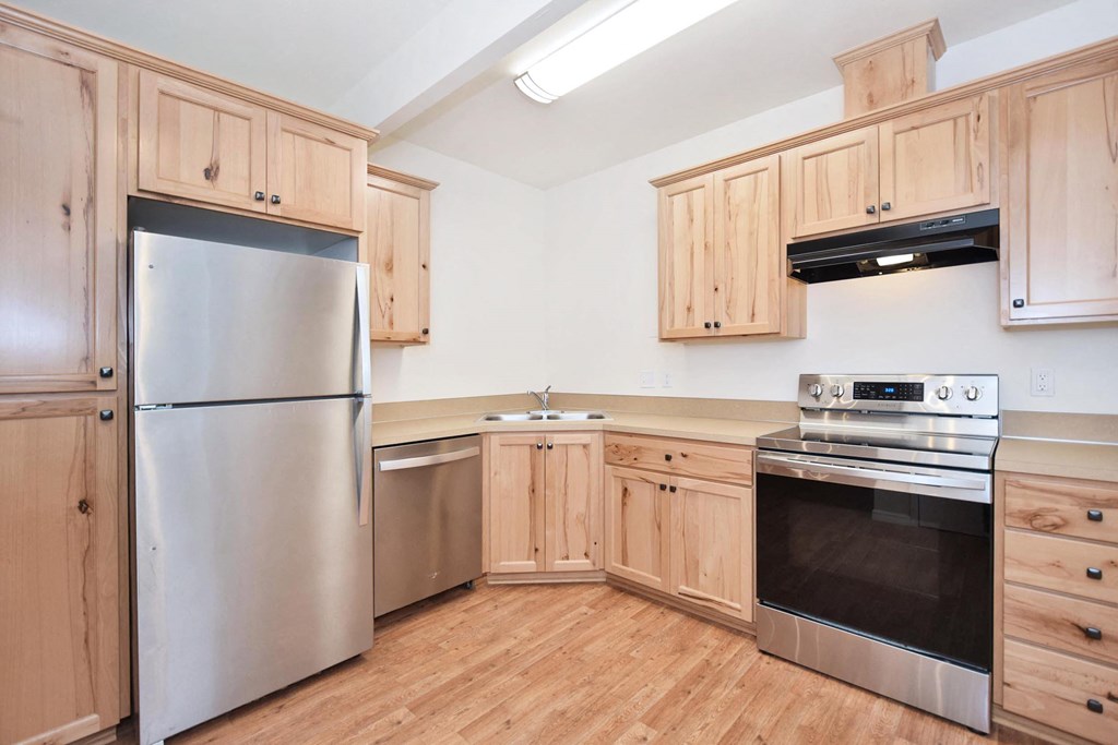 a kitchen with wooden cabinets and stainless steel appliances