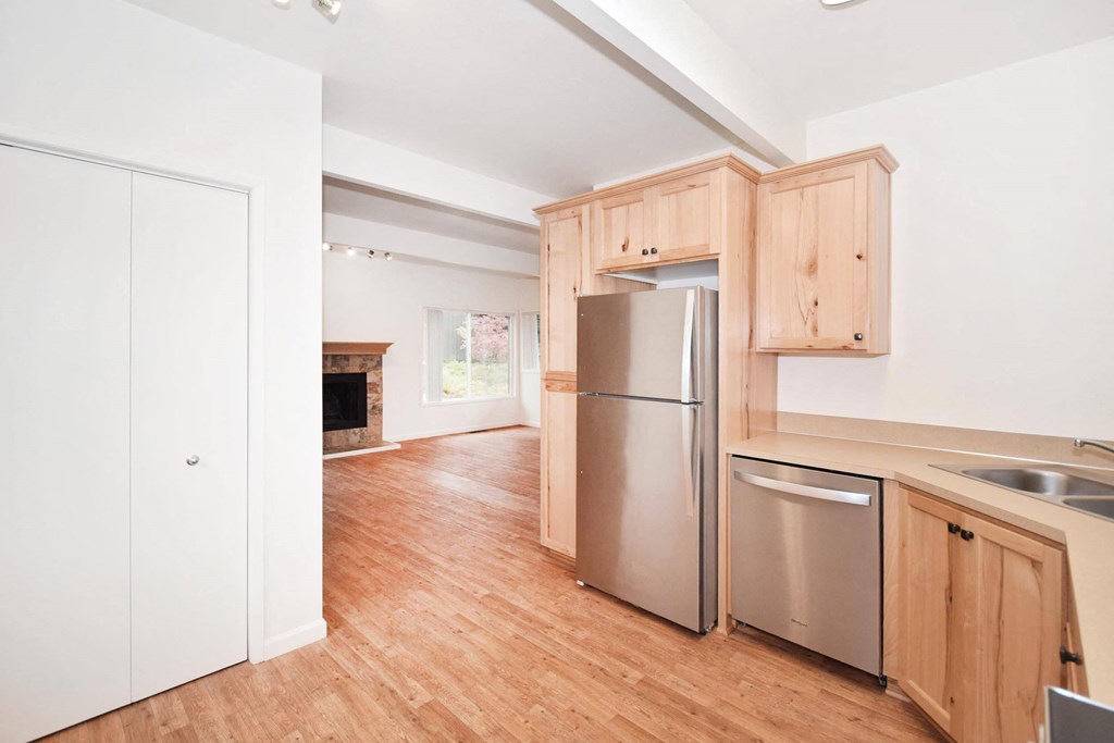 a kitchen with wooden cabinets and a stainless steel refrigerator