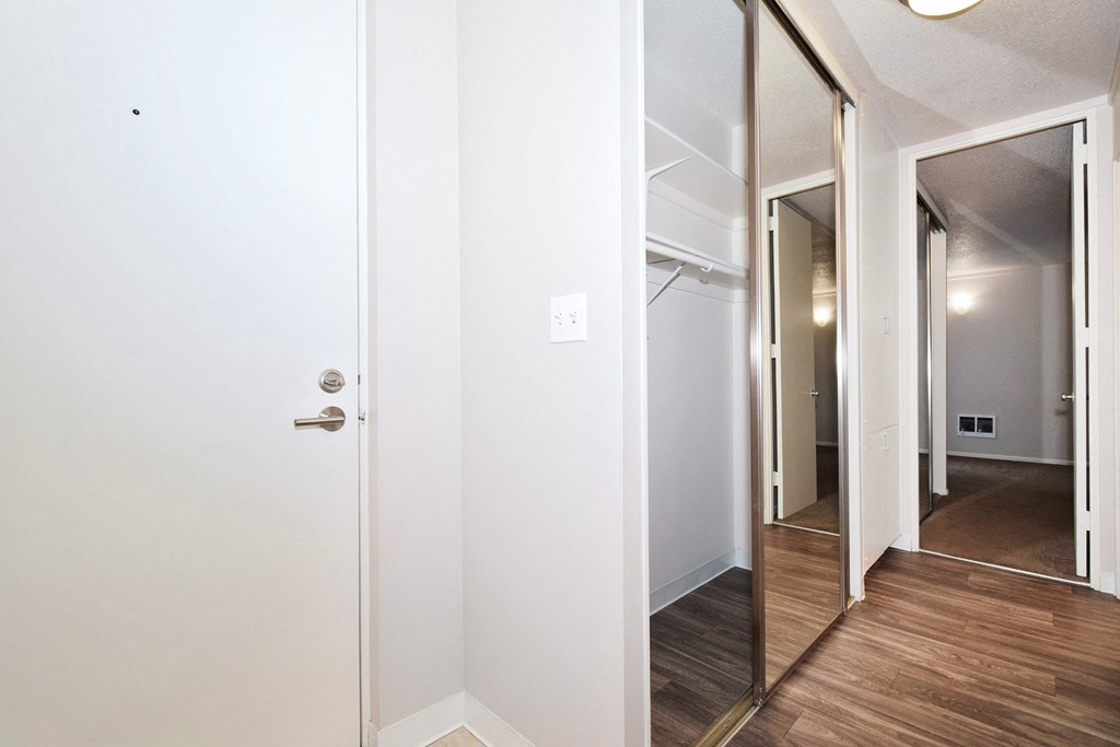 a bedroom with a mirror and a hallway with a door to a closet