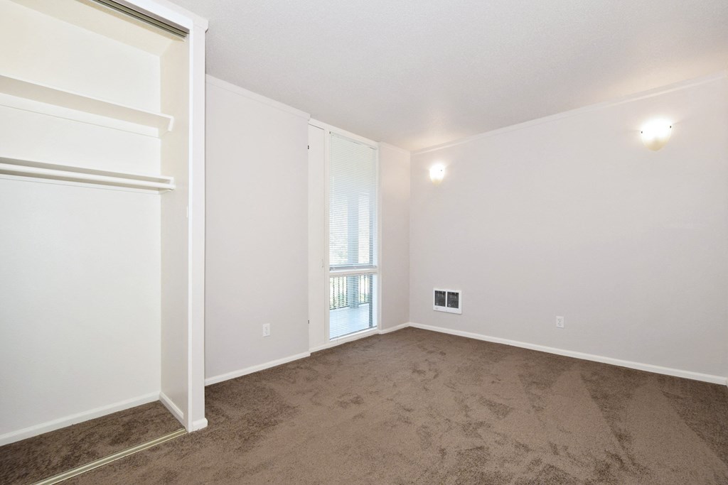 an empty living room with carpet and a window