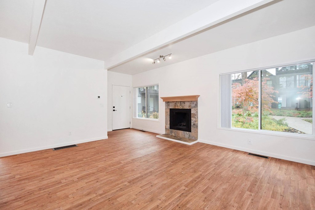 a living room with a wood floor and a fireplace