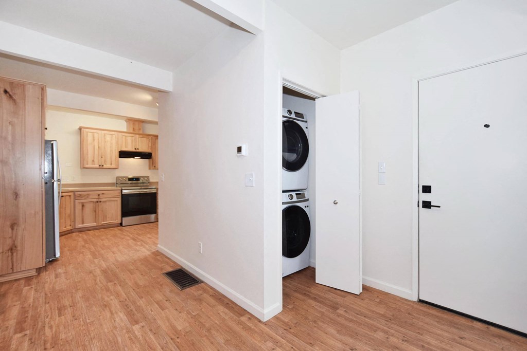 a room with wood floors and white walls and a washing machine
