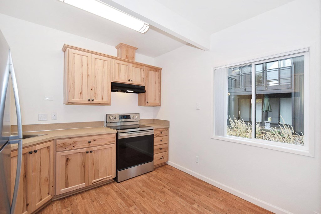 a kitchen with wooden cabinets and a window