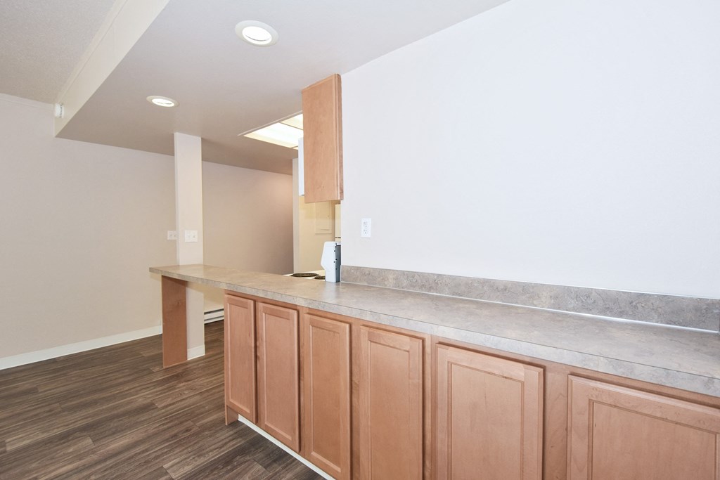 an empty kitchen with wooden cabinets and a counter top