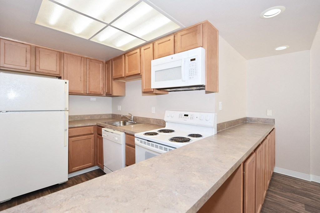 a kitchen with white appliances and wooden cabinets