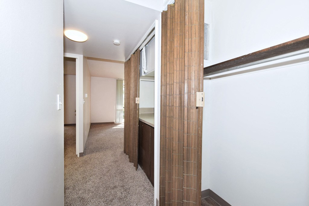 a hallway with a door to a bathroom and a closet