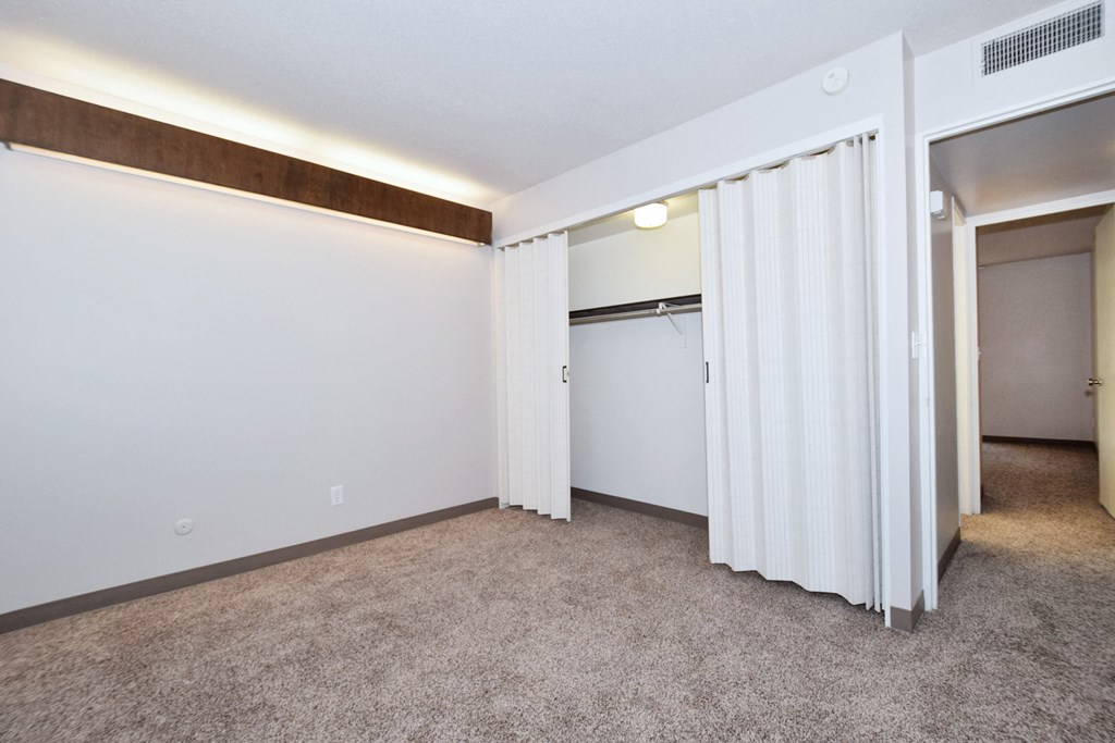 an empty room with white walls and a door to a closet