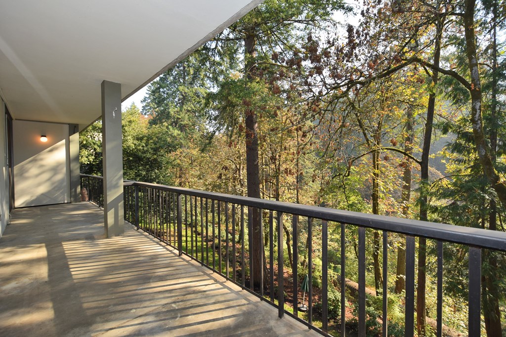 a balcony with a view of a forest