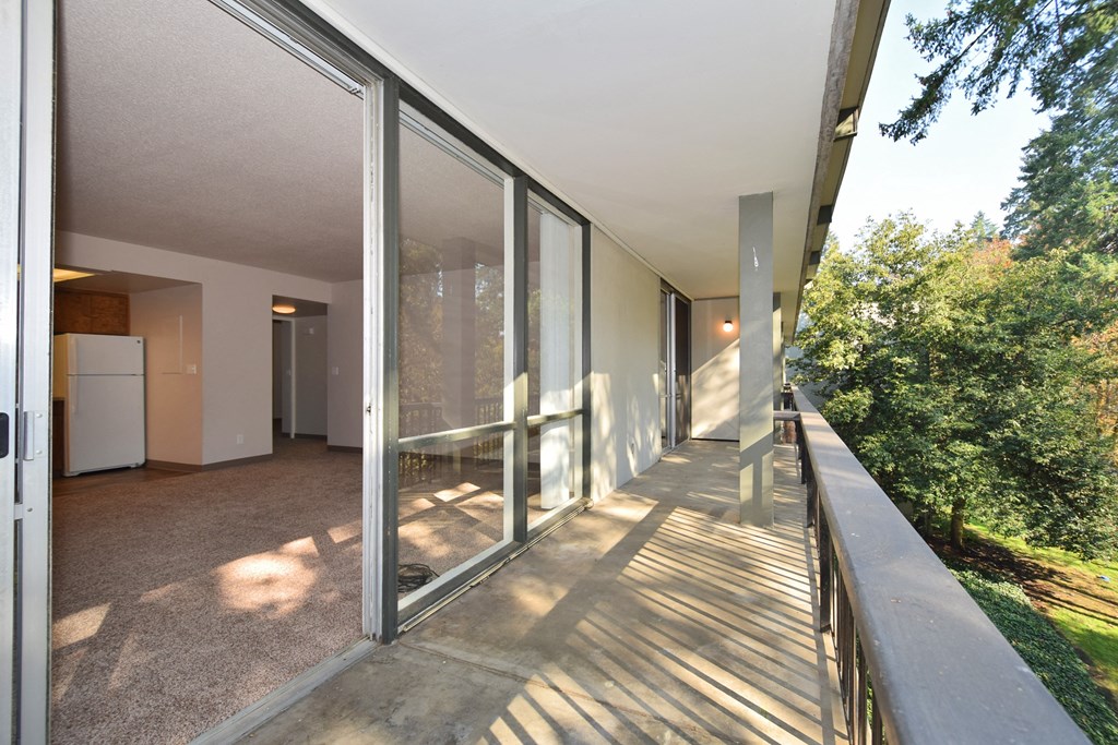 a balcony with a view of a yard and glass doors