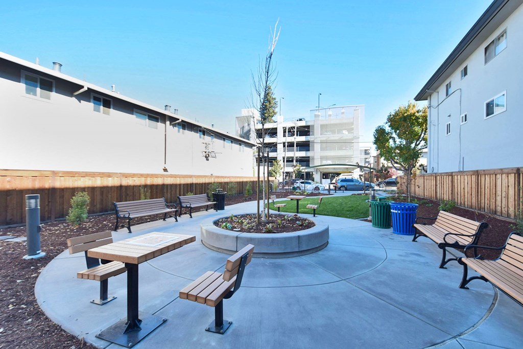 an outdoor seating area with benches and a fire pit