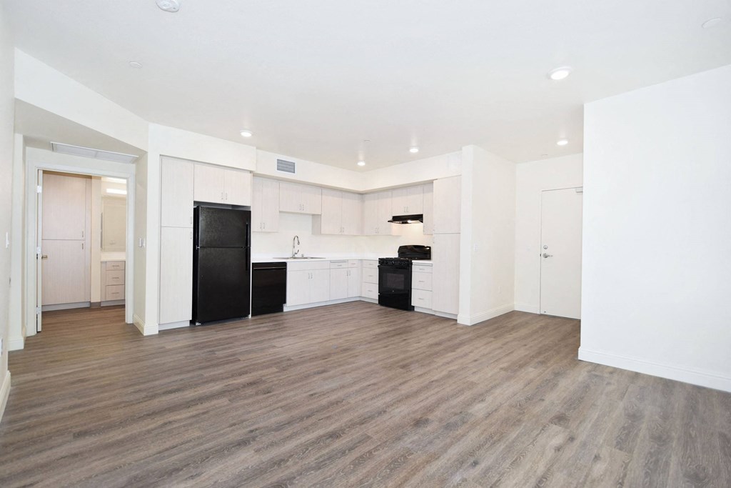 an empty room with white walls and wood floors