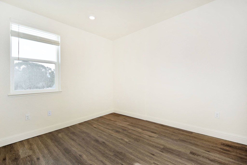 an empty room with white walls and a window