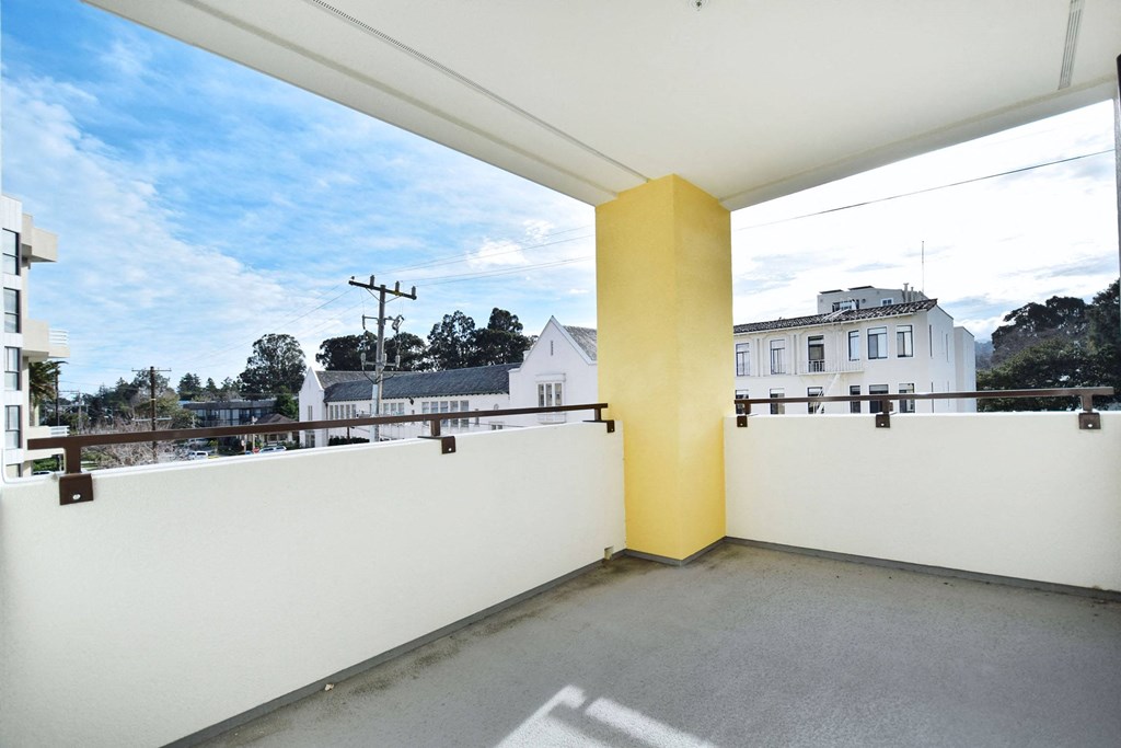 a balcony with a view of the city and a yellow pillar