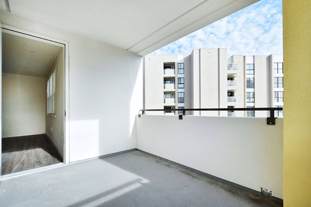 an empty room with a balcony overlooking an apartment building