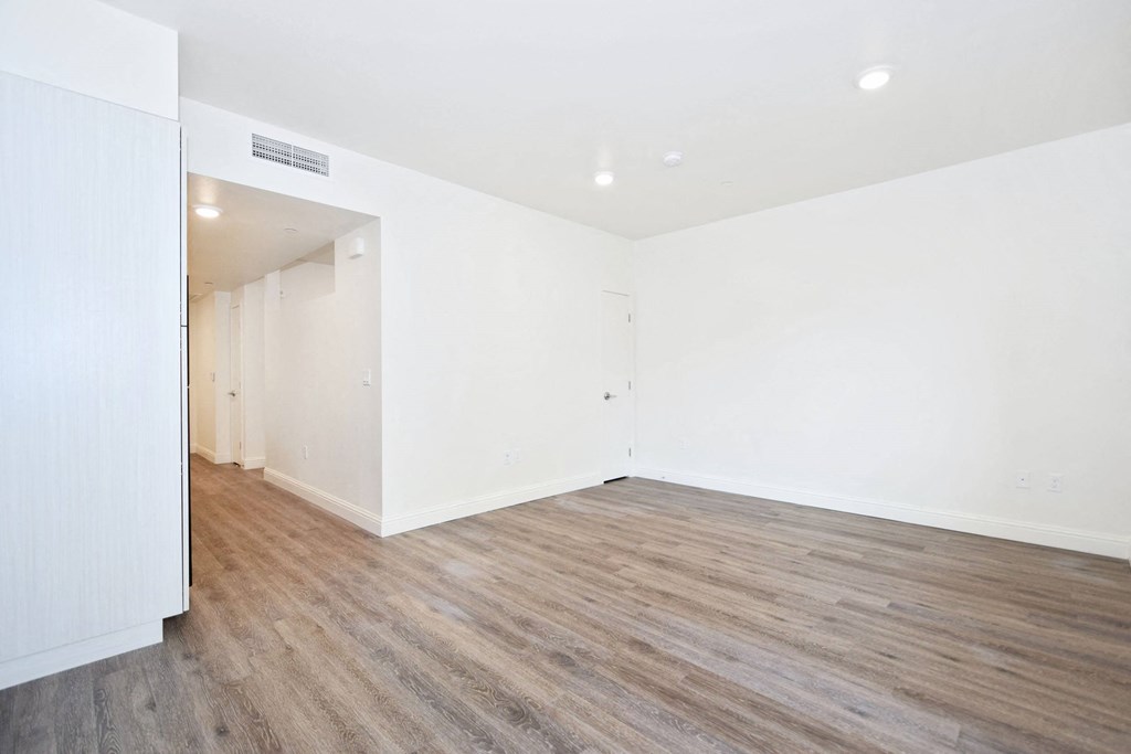 an empty living room with white walls and wood floors