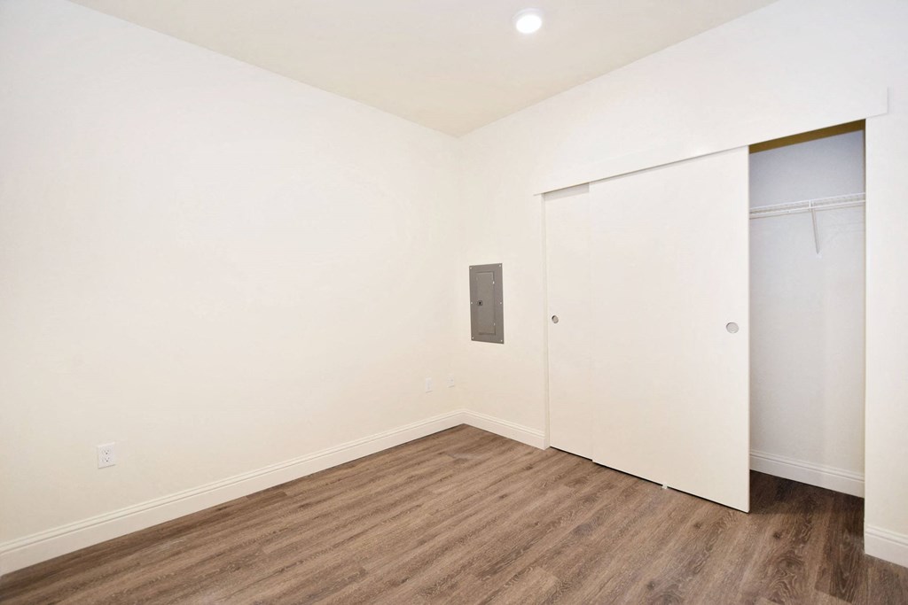 an empty room with white walls and wooden floors