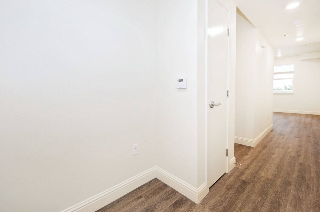 a living room with white walls and wood floors