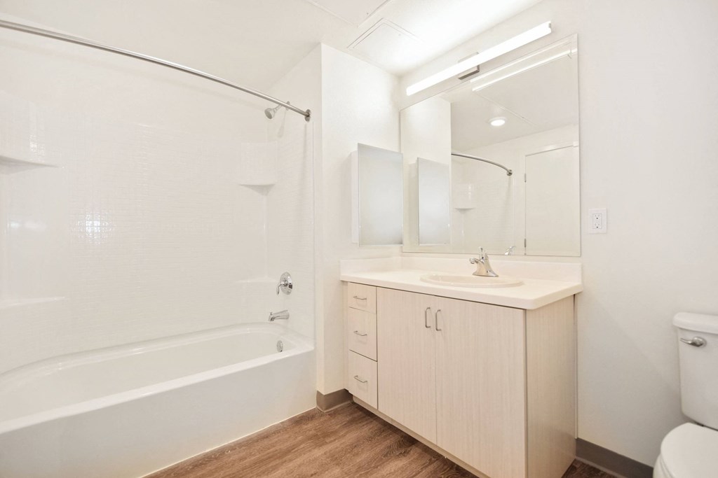 a bathroom with a shower sink and toilet and a mirror