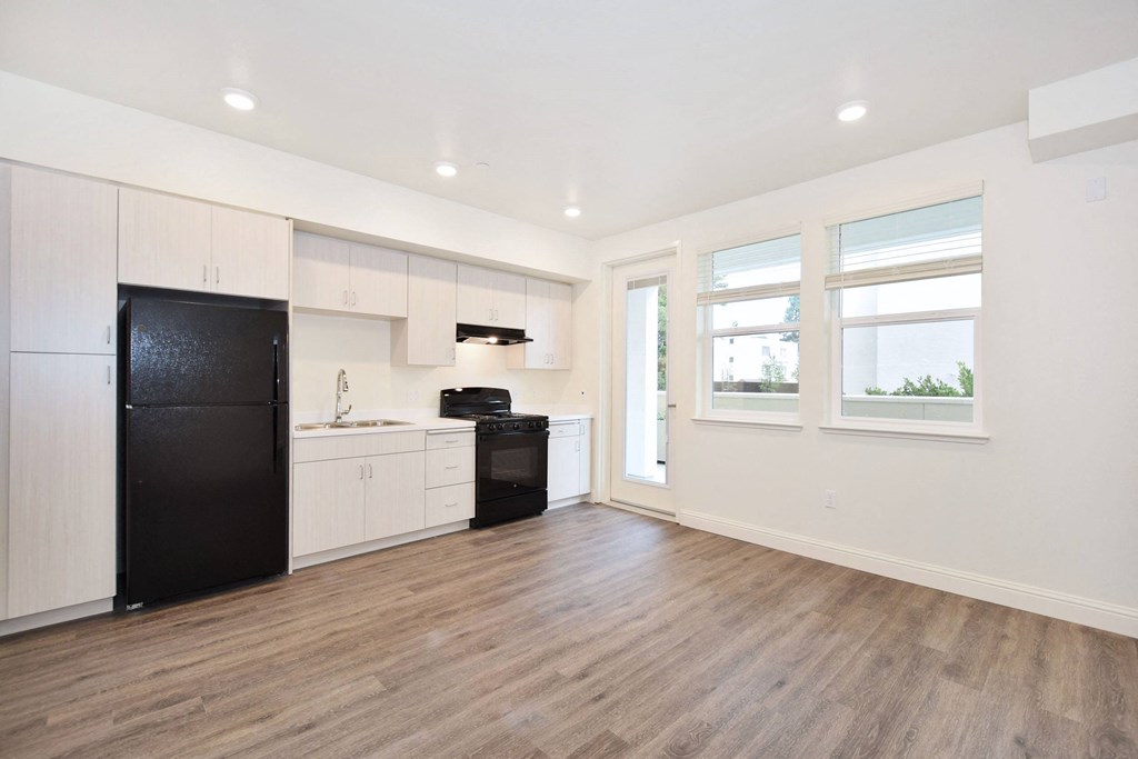 a kitchen with white cabinets and a black refrigerator