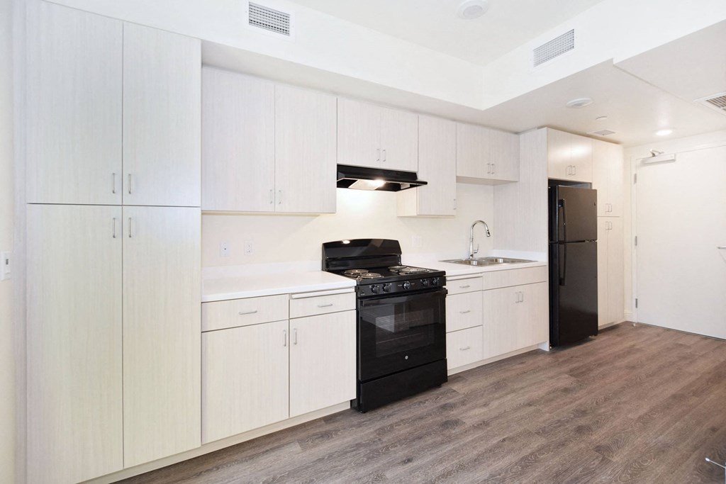 a kitchen with white cabinets and a black stove