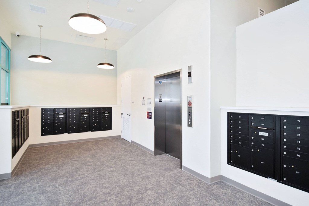 the lockers in the hallway of a building with white walls and grey carpet