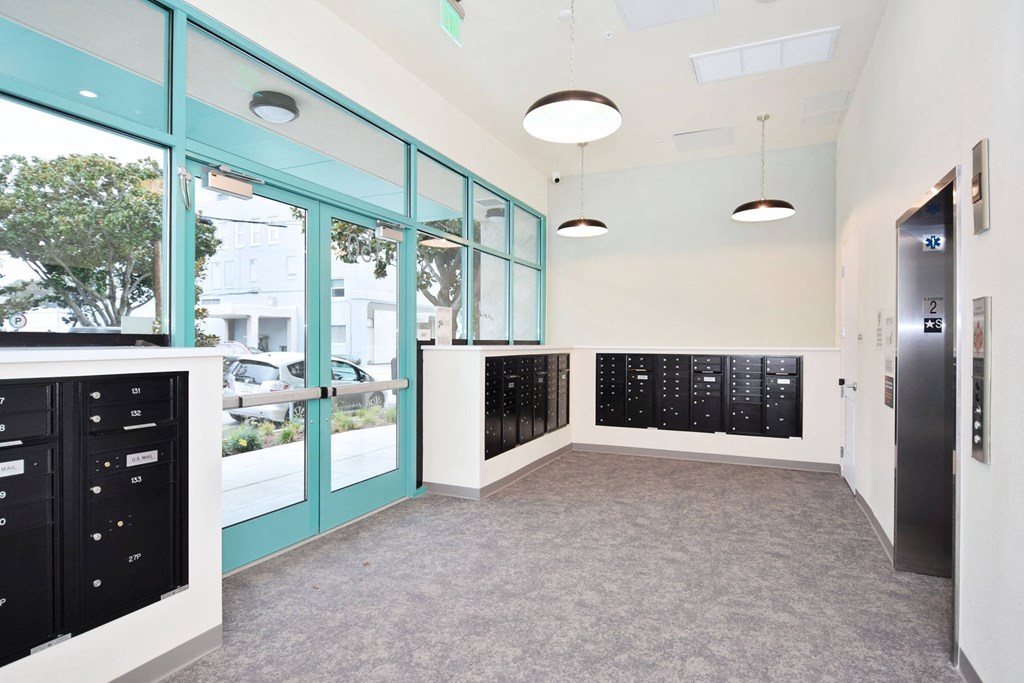 a hallway with a door to a locker room with black lockers