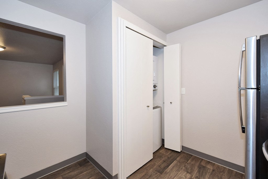 a kitchen with a refrigerator and a mirror on the wall
