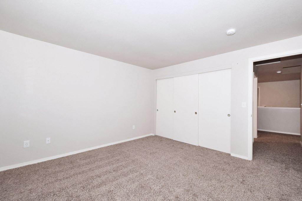 an empty living room with white walls and carpet